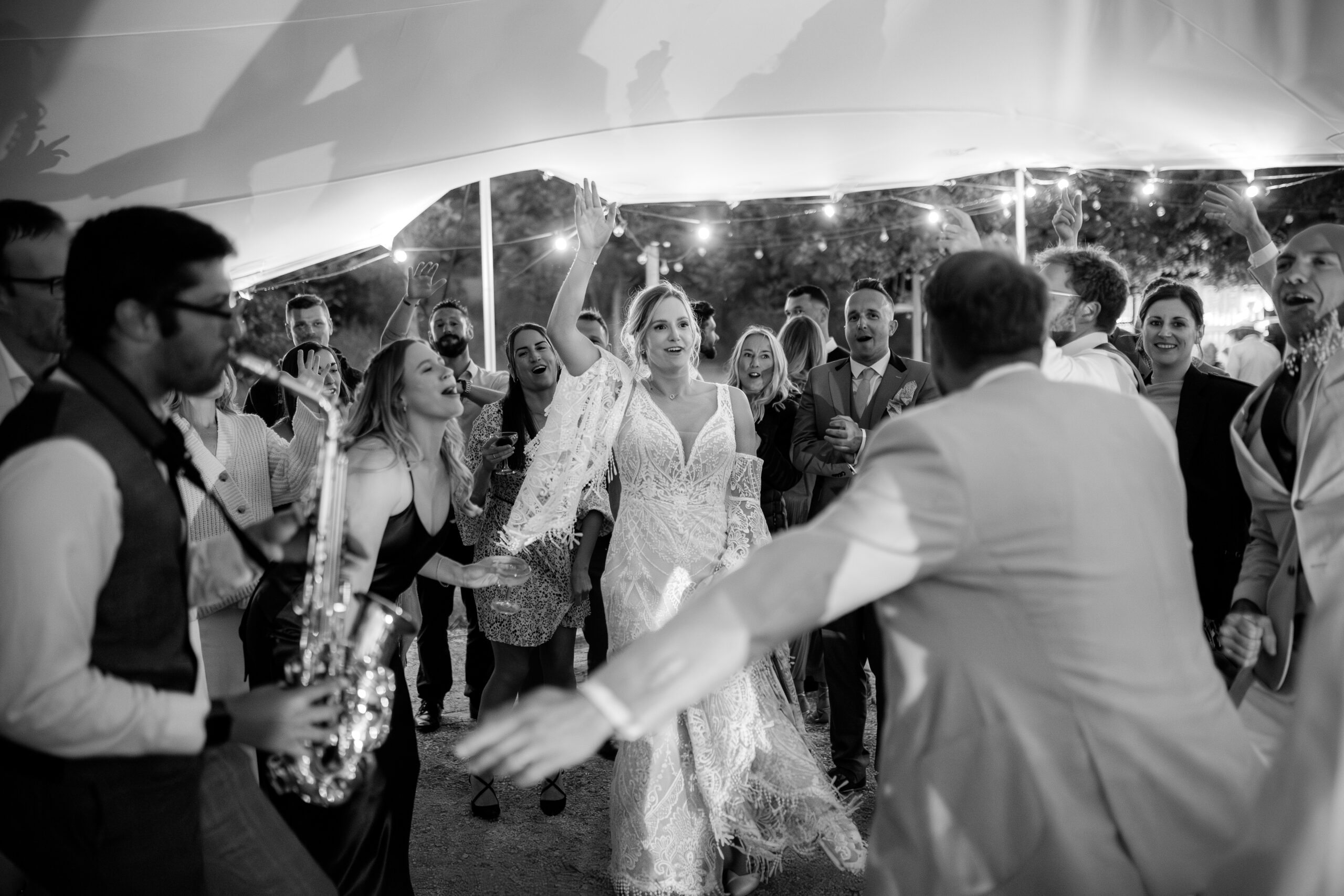 Getting the party started playing the saxophone with the bride, groom and guests dancing around.